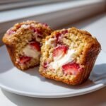 Aufgeschnittener Muffin mit Erdbeeren und cremiger Frischk&auml;sef&uuml;llung: Decadent Strawberry Cream Cheese Muffins.