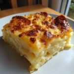 Ein St&uuml;ck Easy Creamy Cheesy Potato Gratin mit goldbraun gebackener K&auml;sekruste.