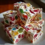 Stapel von wei&szlig;en Nougat-St&uuml;cken, gef&uuml;llt mit bunten Gumdrops und N&uuml;ssen, ideal f&uuml;r Festive Easy Christmas Gumdrop Nougat Candy.