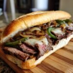 Nahaufnahme eines Quick Delicious Philly Cheesesteak Sandwich mit saftigem Steak, K&auml;se, Zwiebeln und Paprika.