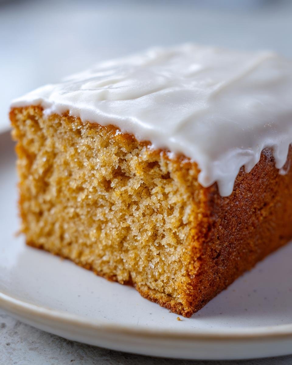 Nahaufnahme eines St&uuml;cks Rebel Float Frosted Banana Bread mit cremigem wei&szlig;en Zuckerguss.