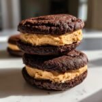 Zwei gestapelte Brownie Cookie Dough Sandwich Cookies mit cremiger Erdnussbutterf&uuml;llung.