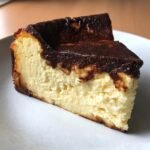 Nahaufnahme eines cremigen St&uuml;cks Burnt Basque Cheesecake mit dunkler, karamellisierter Kruste.