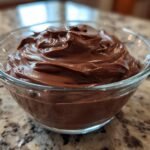 Nahaufnahme von cremigem, selbstgemachtem Schokoladenpudding in einer Glasschale.