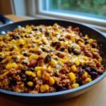 Nahaufnahme eines gesunden Puten-Taco-Pfannengerichts mit Hackfleisch, Mais, schwarzen Bohnen und geschmolzenem K&auml;se.