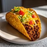 Ein knuspriger Taco gef&uuml;llt mit gew&uuml;rztem Hackfleisch, K&auml;se, Salat und Tomaten &ndash; Crispy Baked Ground Beef Tacos.