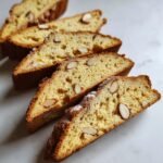 Aufgeschnittene Scheiben von knusprigem Limoncello Mandel Biscotti mit sichtbaren Mandelst&uuml;cken.