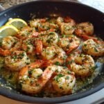 Nahaufnahme von saftigen Garnelen im Lemon Garlic Shrimp Skillet mit Knoblauch, Petersilie und Zitronenscheiben.