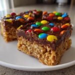 Nahaufnahme von saftigen Irresistible M M Chocolate Fudge Oatmeal Bars mit Schokoladenglasur und bunten M&Ms.