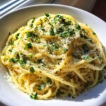 Nahaufnahme von One Pan Butter Parmesan Pasta, bestreut mit geriebenem K&auml;se und frischer Petersilie.