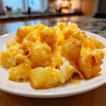 Nahaufnahme von knusprigen Kartoffelw&uuml;rfeln, &uuml;berbacken mit geschmolzenem Cheddar-K&auml;se, ein perfektes Quick Easy One Pan Cheesy Potato Skillet.
