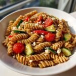 Nahaufnahme eines Quick Healthy Pasta Salad In 20 Minutes mit Spiralnudeln, Kirschtomaten, Zucchini und Feta.