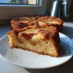 Nahaufnahme eines saftigen St&uuml;cks Italian Pear Cake mit karamellisierter Kruste und Birnenst&uuml;cken auf einem wei&szlig;en Teller.