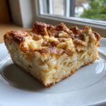 Ein St&uuml;ck der Sweet White Chocolate Brownie Pizza auf einem wei&szlig;en Teller mit karamellisierter, goldbrauner Oberfl&auml;che.