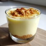 Nahaufnahme von cremigen Lemon Mousse Dessert Cups mit Keksboden und Streuseltopping.