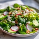 Nahaufnahme eines bunten Spring Salad mit Spinat, Radieschenscheiben, Gurken und Feta-K&auml;se.